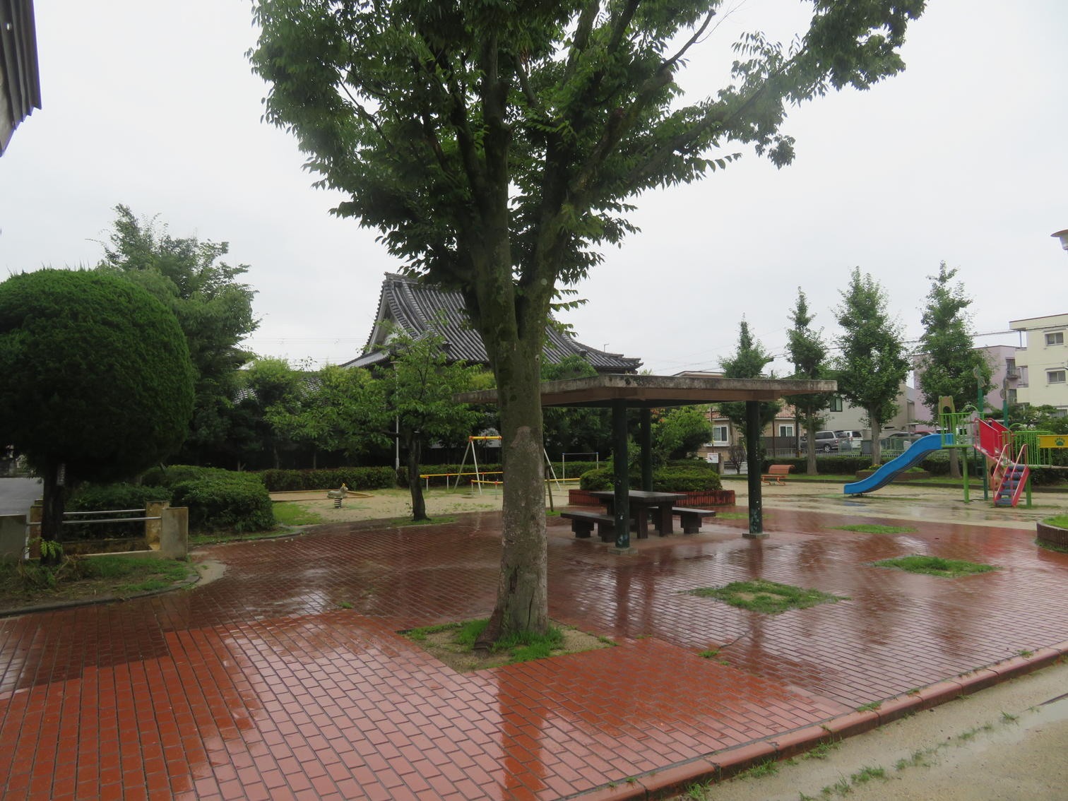 遊具と休憩所がある雨天の春日町公園