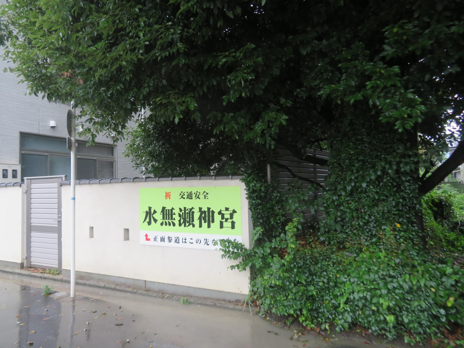 雨に濡れた島本町広瀬の道路と水無瀬神宮への案内標識