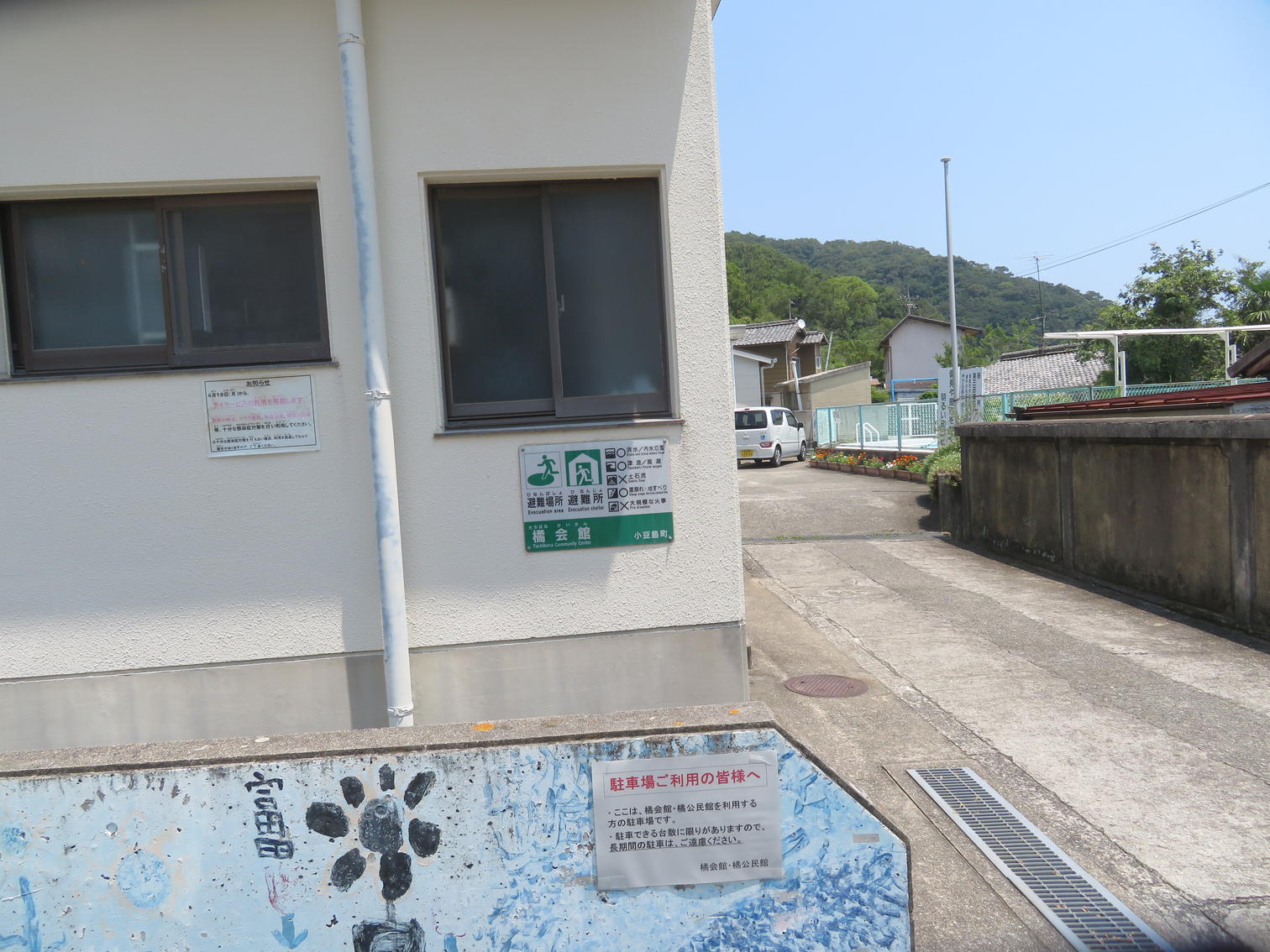橘会館側面の避難場所表示と駐車場案内
