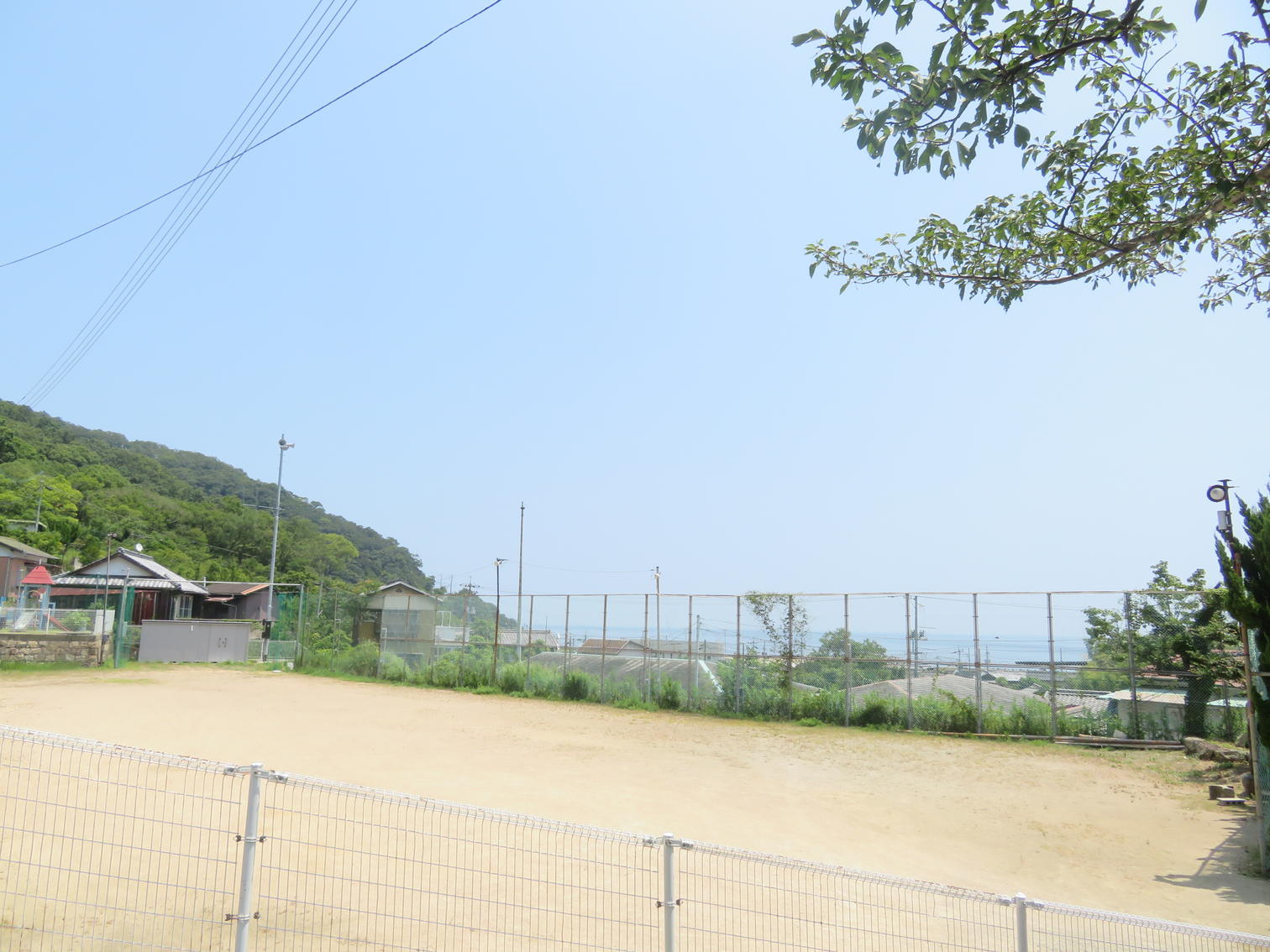 旭幼稚園付近の土の運動場と山並み