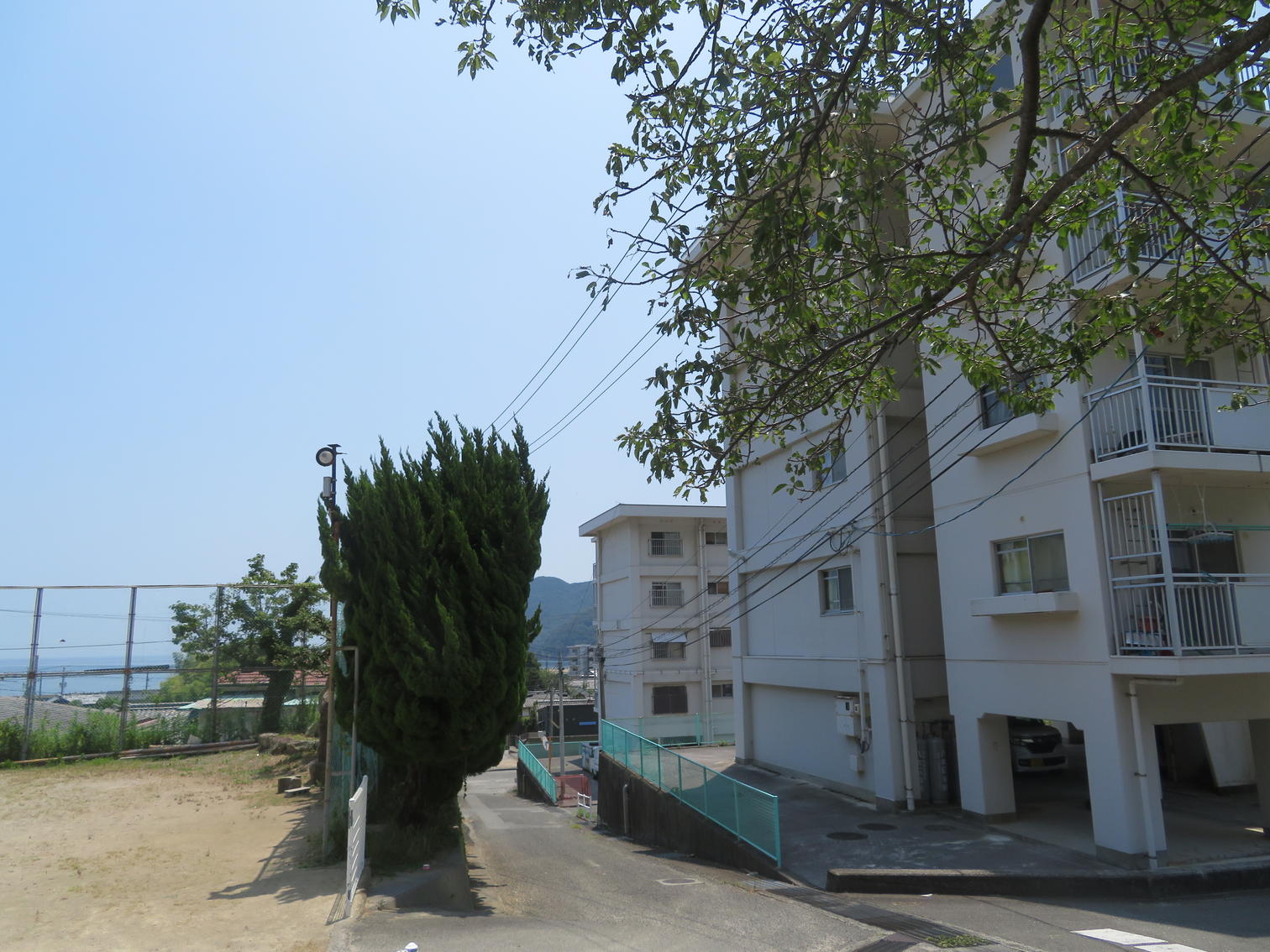 運動場に隣接する白い中層住宅