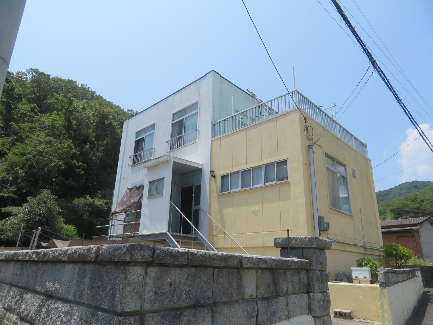 山際に建つ白と淡黄色の建物