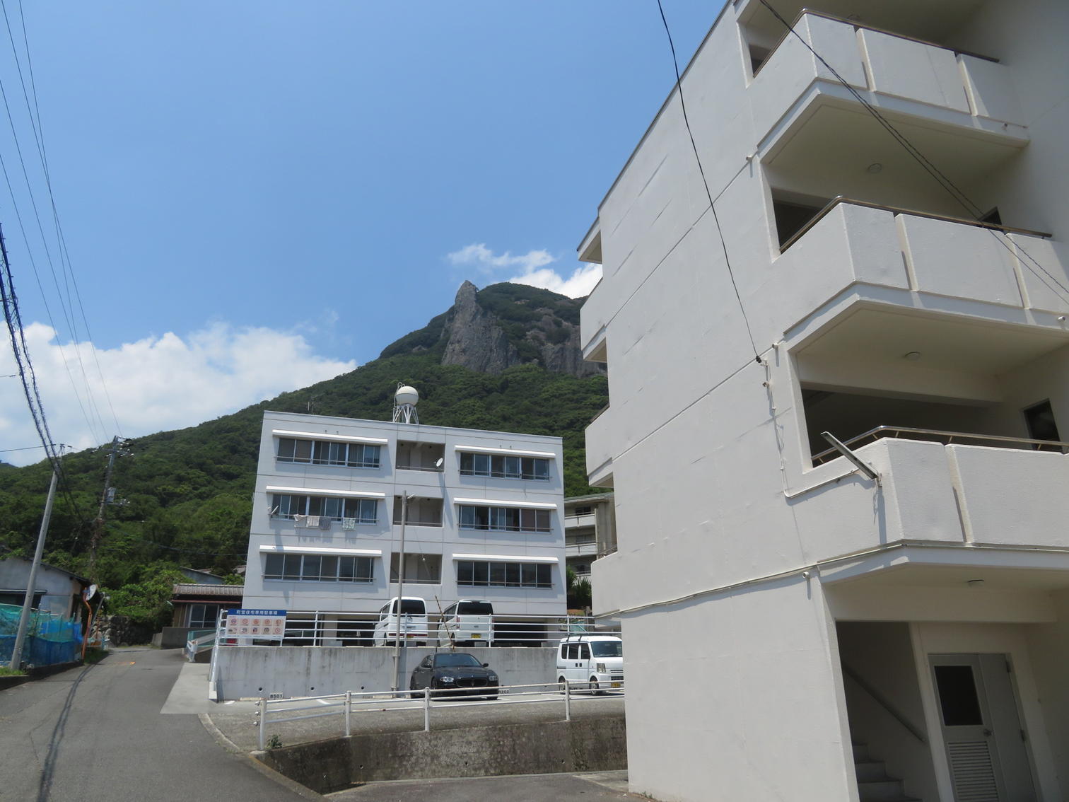 白い住宅棟の背後に迫る岩山