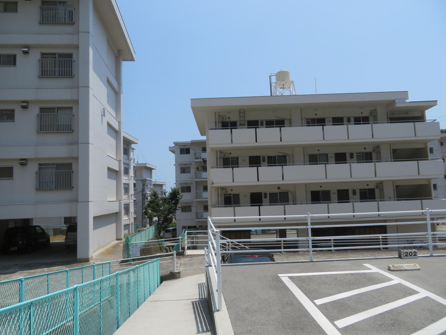 空き駐車区画の向こうに建つ町営住宅