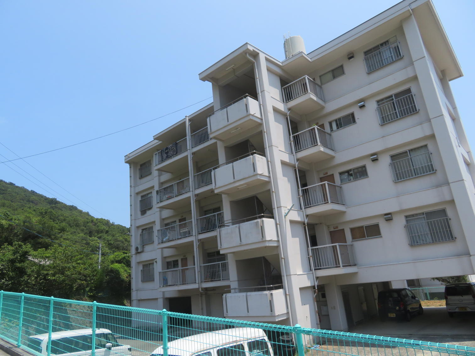 山裾に建つ5階建ての白い住宅棟