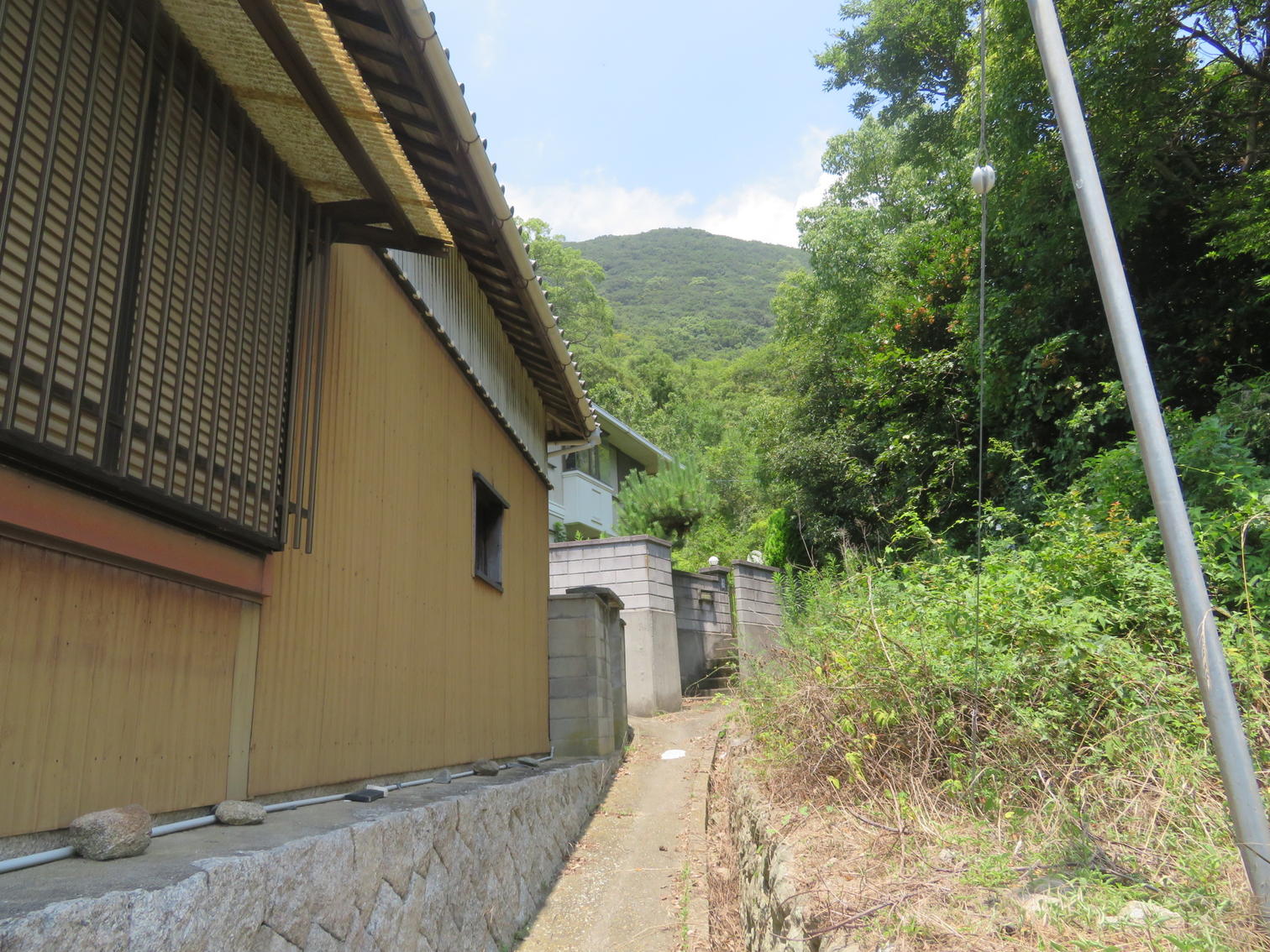 木造家屋の脇を山側へ上る道