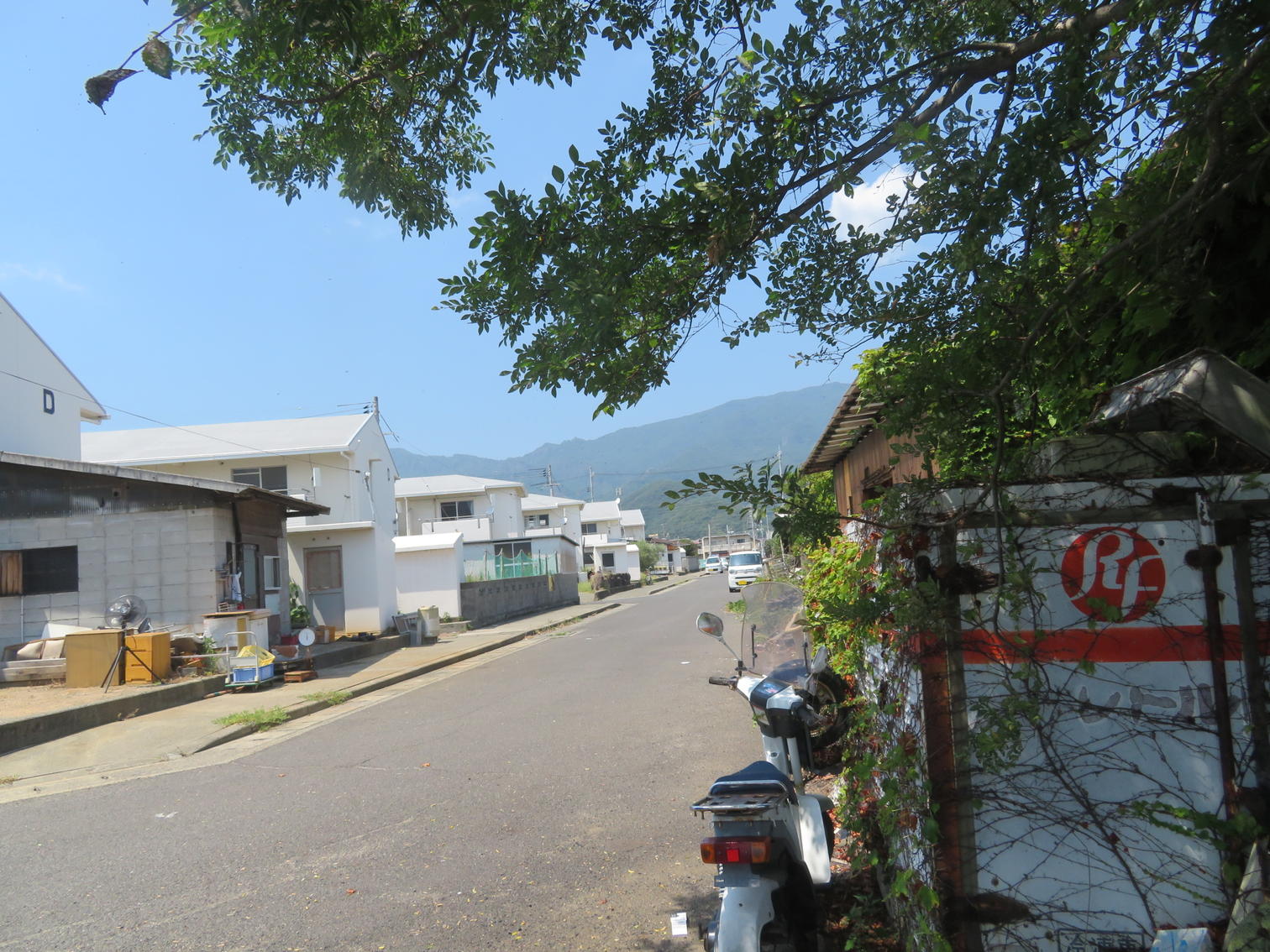 海に向かって並ぶ小豆島町草壁本町の白い2階建て住宅と通り