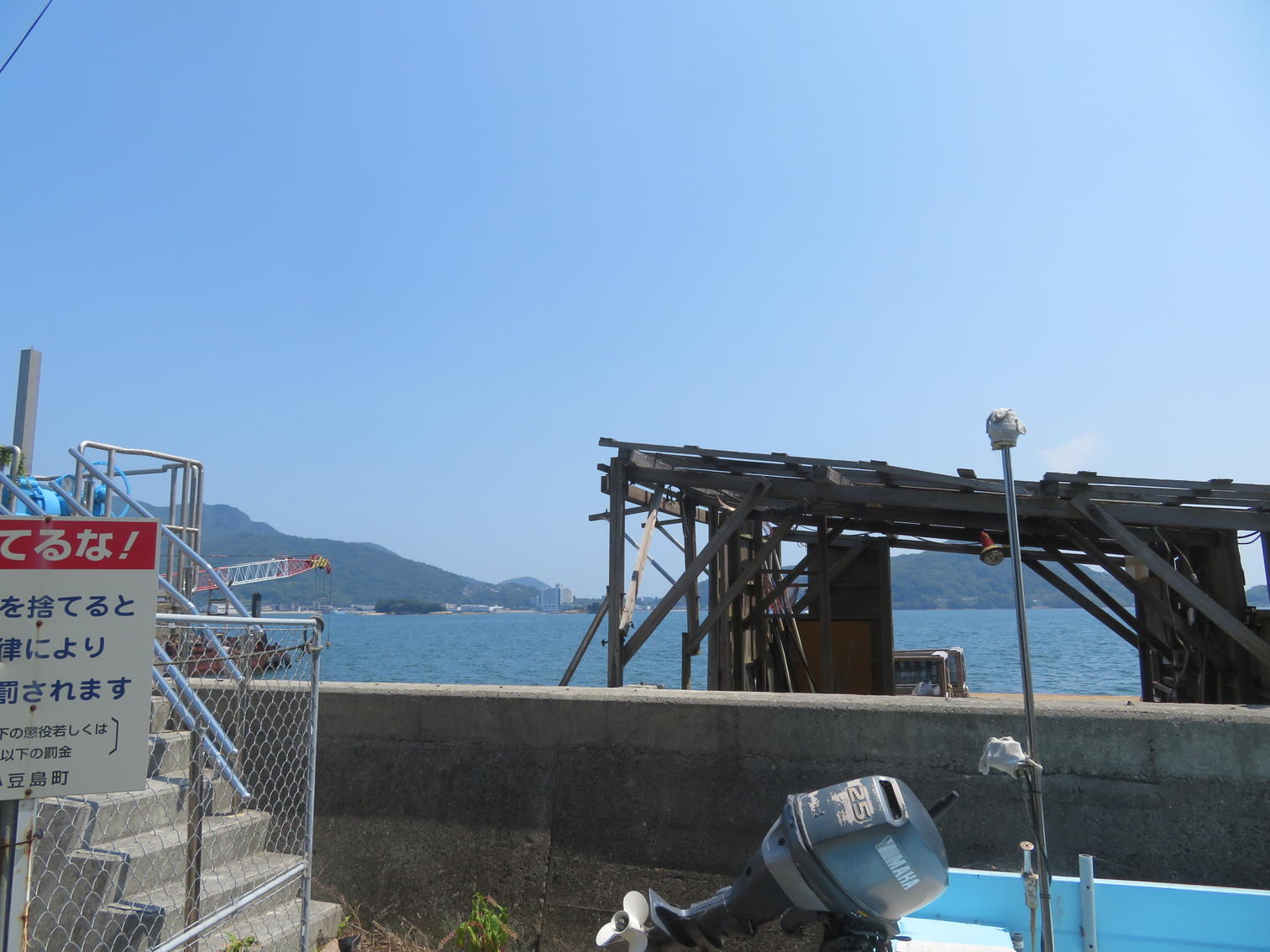 護岸の柵に付けられた小豆島町のごみ捨て禁止の看板と海
