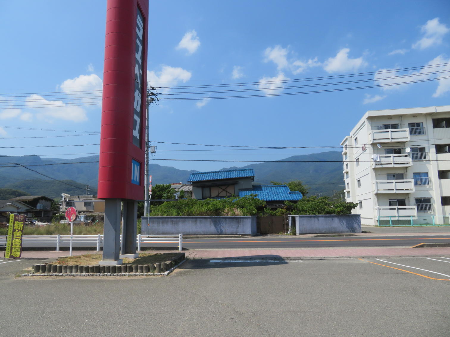 遊技場の看板の向こうに見える3階建て住宅