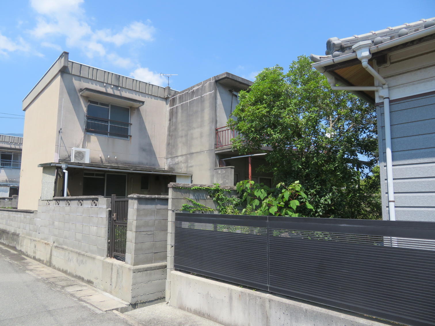 古い2階建て住宅とブロック塀