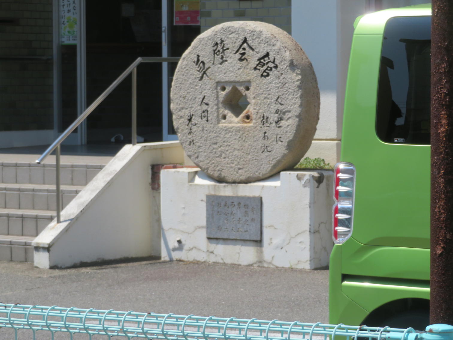 草壁会館と刻まれた丸い石碑。人の世に熱あれ人間に光あれの文字