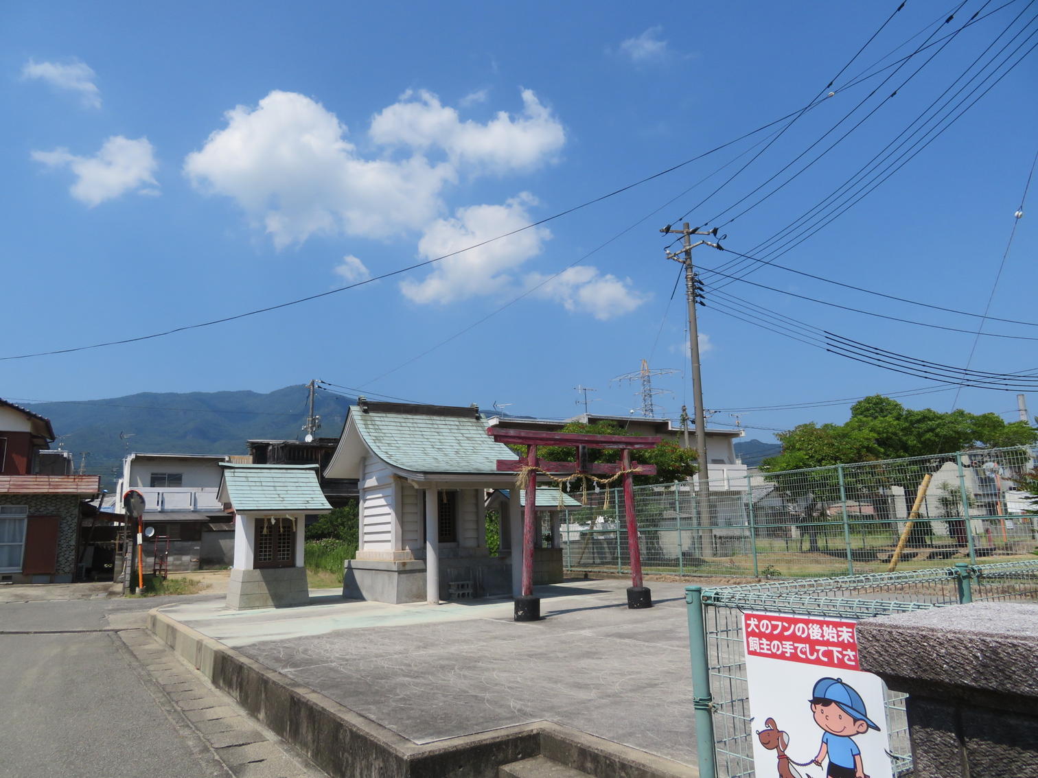 公園の脇に建つ小さな社と赤い鳥居