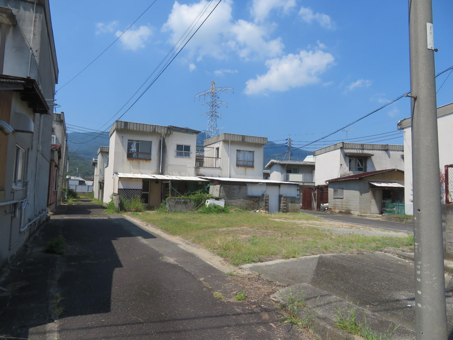 2階建て住宅が並ぶ通りと空き地