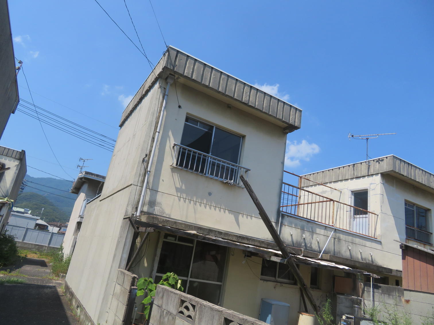 外壁の傷んだ2階建て住宅