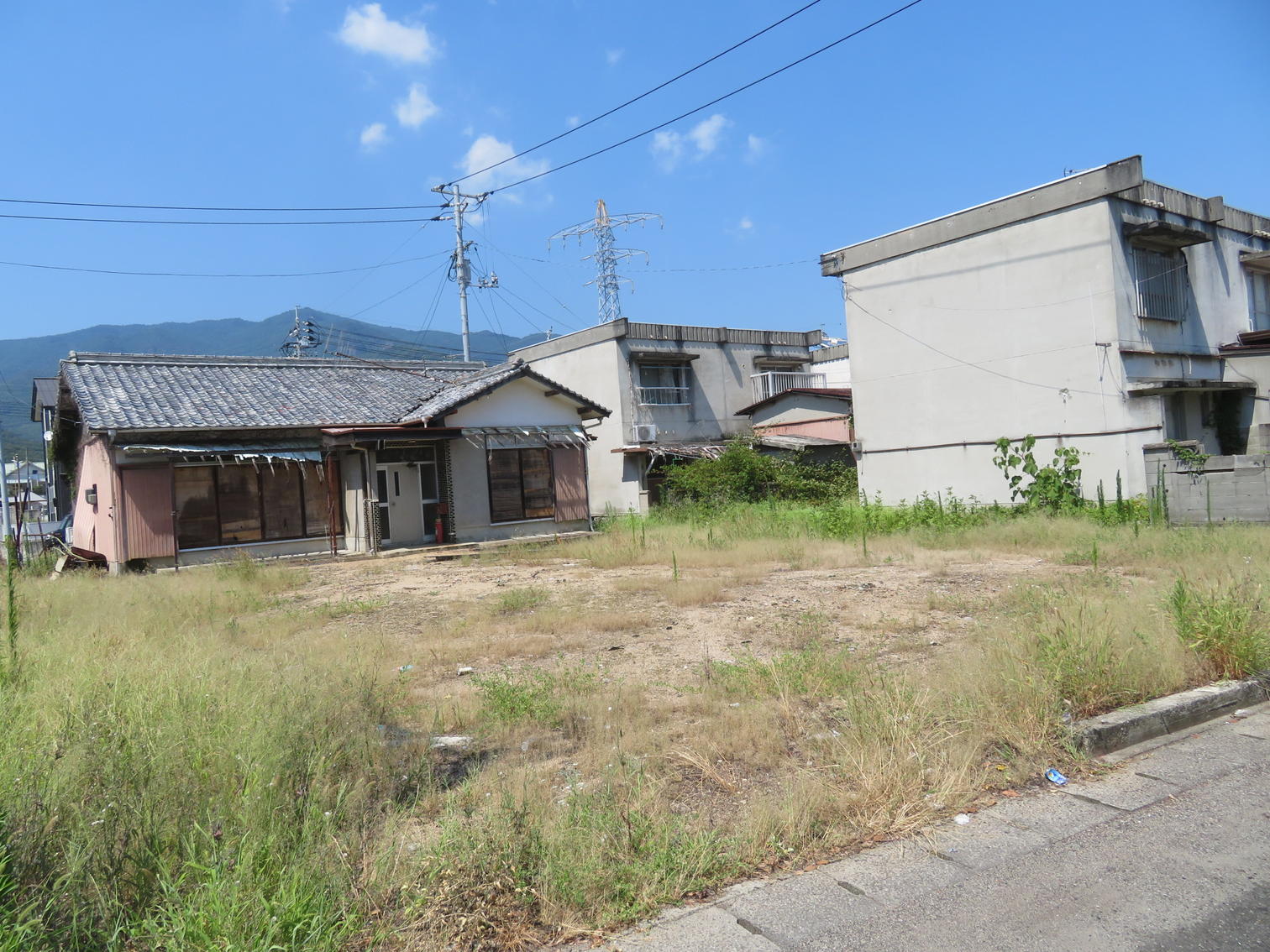 空き地と平屋の住宅と2階建て住宅