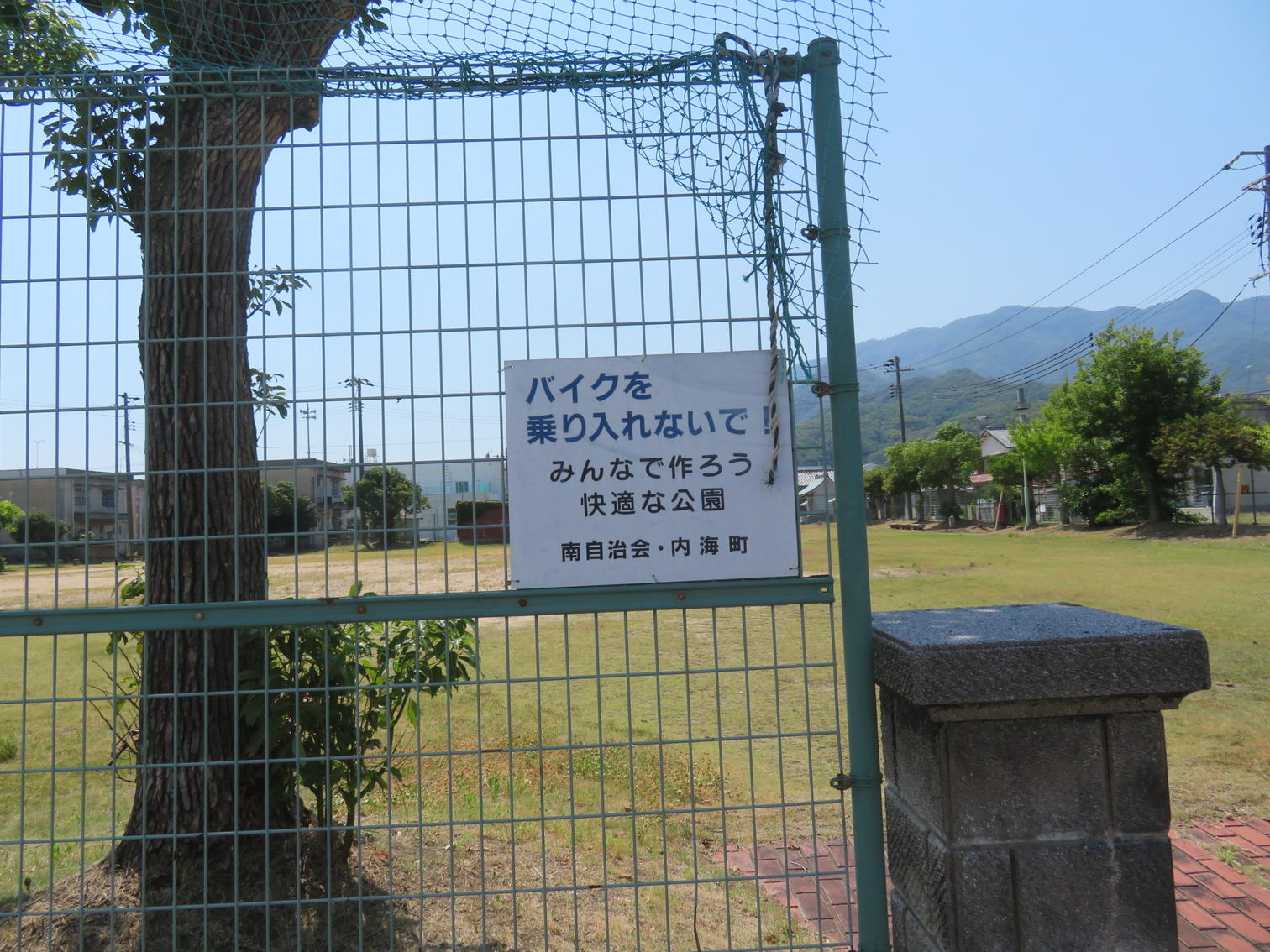 公園の柵に付けられたバイク乗り入れ禁止の看板。南自治会・内海町の名前