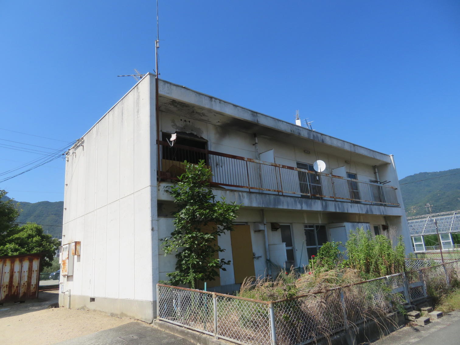 外壁の傷みが目立つ2階建ての住宅。