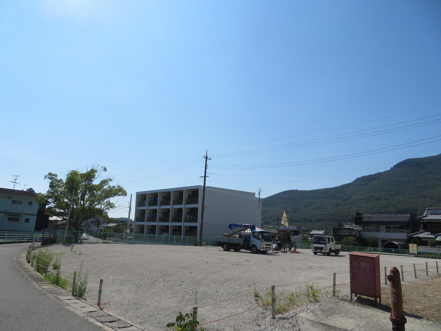 広い空き地の向こうに建つ集合住宅。
