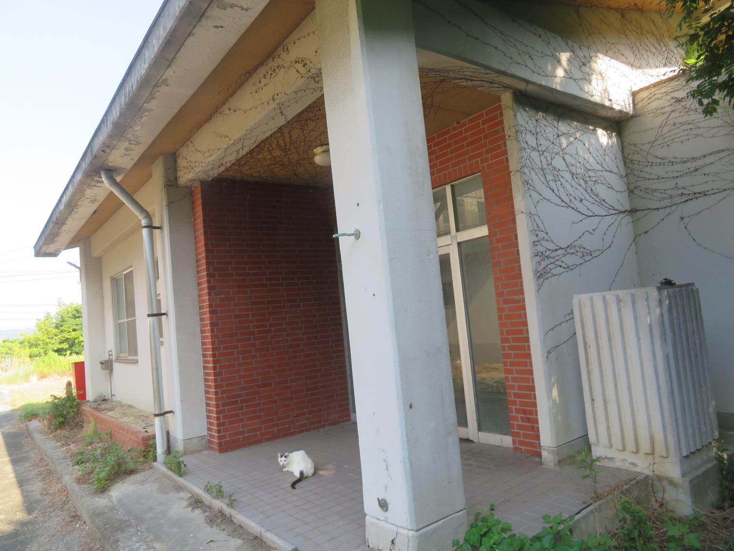 青い柵と白い2階建ての家。