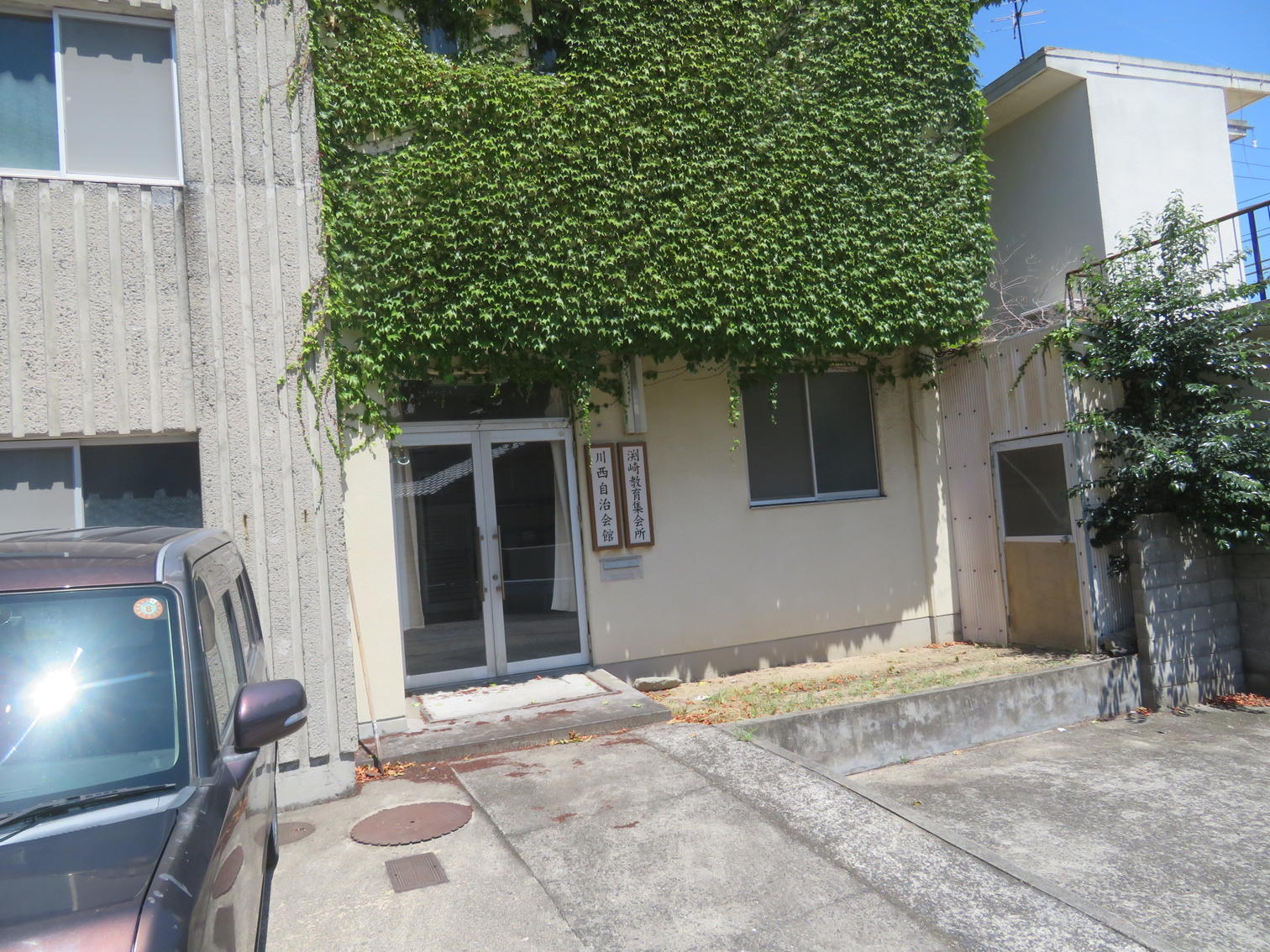 入口に「川西自治会館」と「渕崎教育集会所」の表札が並ぶ。