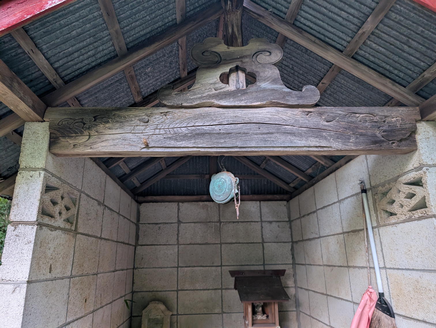 ブロック積みの祠。軒に鰐口が下がっている。